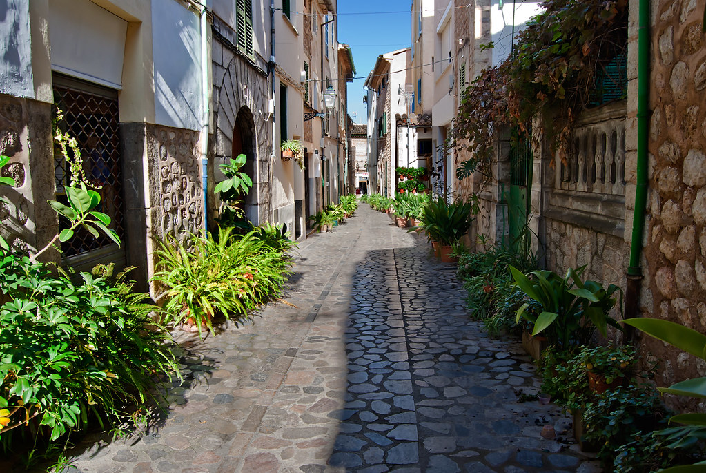Imagen de una calle del pueblo de Sóller con gran cantidad de macetas cuidadas por los vecinos.